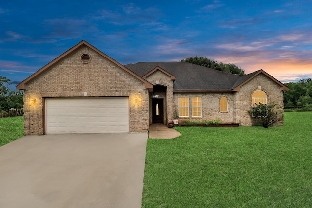 view of front of property featuring a lawn and a garage