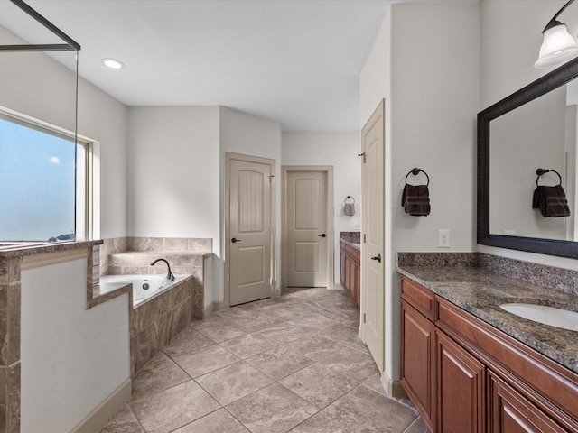 bathroom featuring vanity and tiled bath