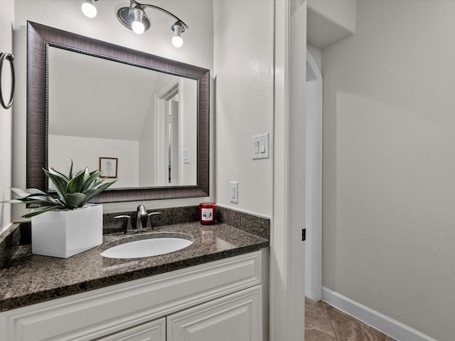 bathroom featuring vanity, tile patterned flooring, and vaulted ceiling