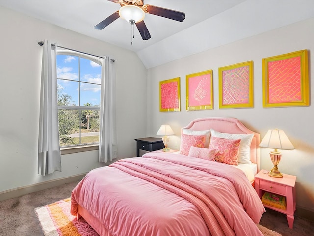 bedroom with ceiling fan, vaulted ceiling, and dark colored carpet