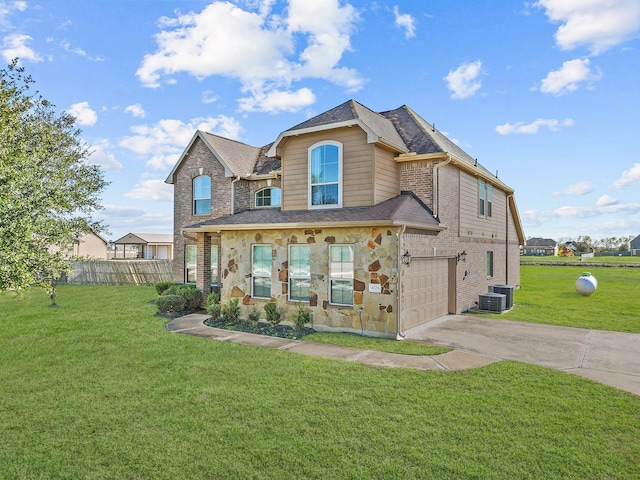 view of front of house with cooling unit, a garage, and a front yard