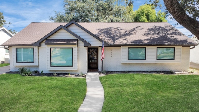 view of front of home featuring cooling unit and a front yard