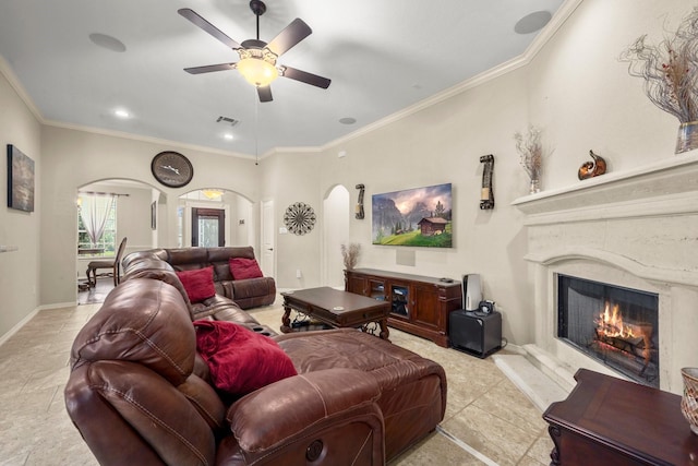 living room featuring ceiling fan, ornamental molding, and a premium fireplace