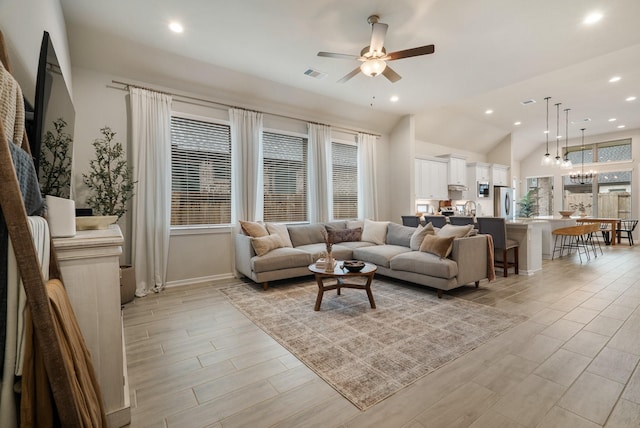 living room with a wealth of natural light, ceiling fan, and lofted ceiling