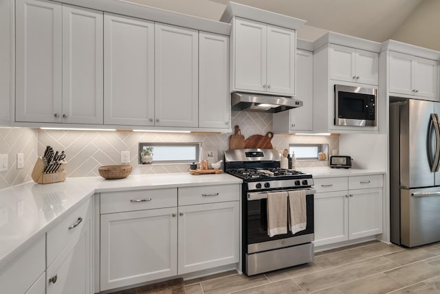 kitchen featuring decorative backsplash, appliances with stainless steel finishes, and white cabinetry