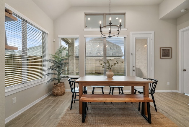 dining space with vaulted ceiling and a notable chandelier