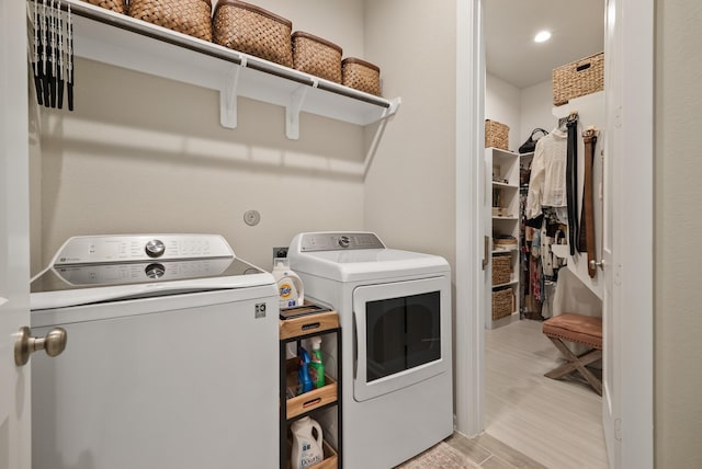 laundry area with washer and dryer and light hardwood / wood-style floors