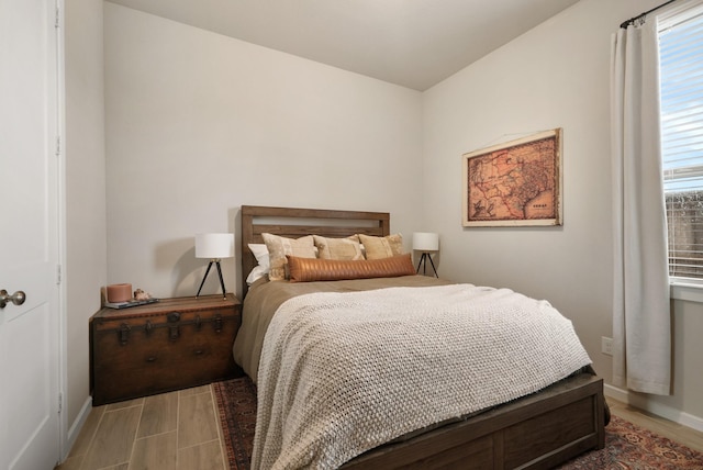 bedroom with light wood-type flooring and multiple windows