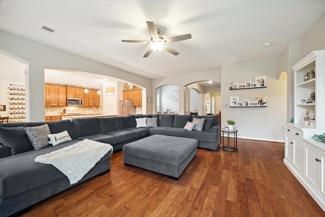 living room with dark hardwood / wood-style floors and ceiling fan