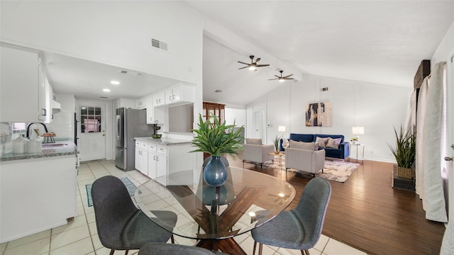 tiled dining area with lofted ceiling with beams, ceiling fan, and sink