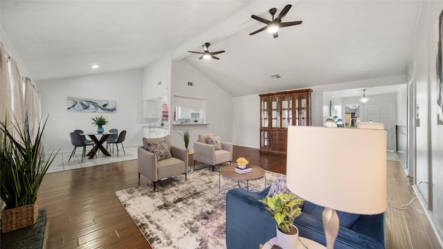 living room with lofted ceiling with beams, dark hardwood / wood-style floors, and ceiling fan