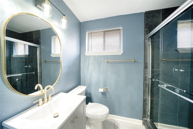 bathroom with tile patterned floors, vanity, toilet, and a shower with door