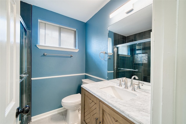 bathroom featuring tile patterned floors, vanity, toilet, and walk in shower