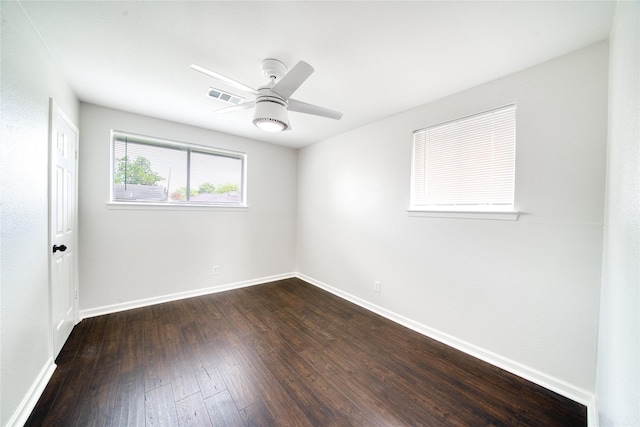 empty room with ceiling fan and dark hardwood / wood-style floors