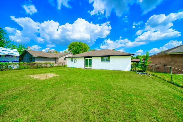 rear view of house featuring a lawn