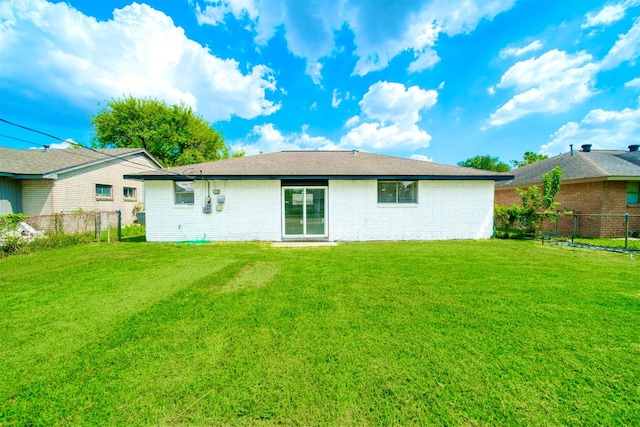 rear view of house with a yard