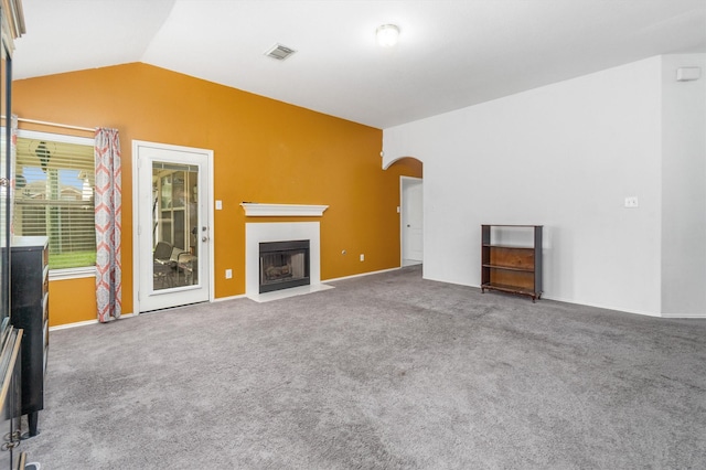 unfurnished living room with carpet and vaulted ceiling