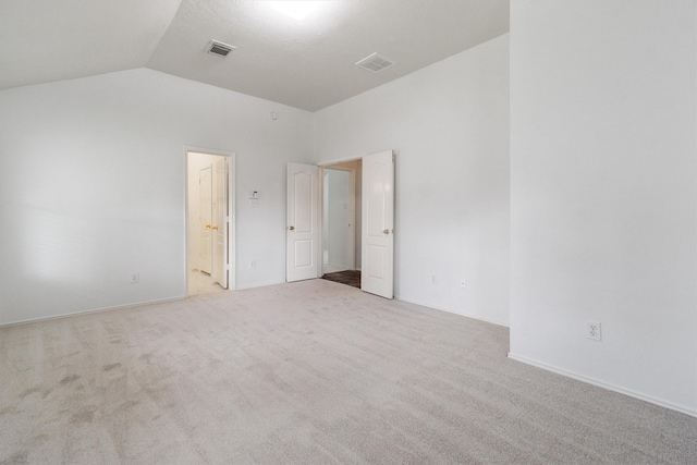 carpeted spare room featuring lofted ceiling