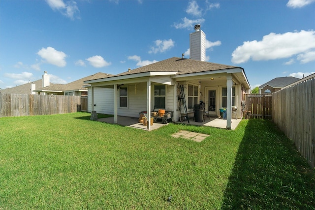 back of house with a patio area and a yard