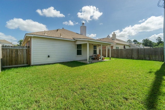 back of house with a lawn and a patio