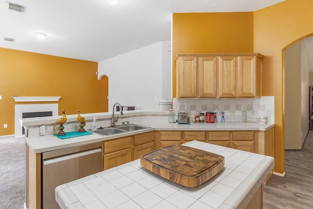 kitchen featuring light brown cabinetry, tile counters, sink, and stainless steel dishwasher