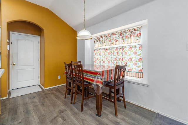 dining space with dark hardwood / wood-style flooring and lofted ceiling