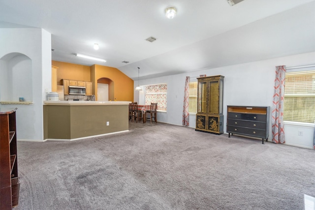 unfurnished living room with dark carpet and lofted ceiling