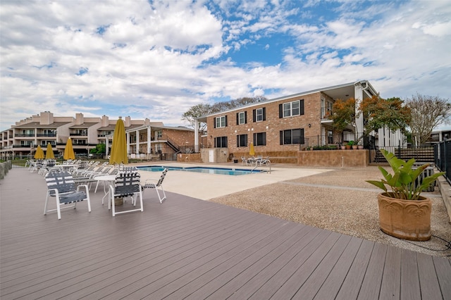 deck featuring a patio and a community pool