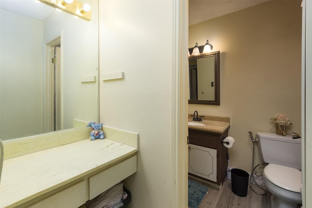 bathroom with hardwood / wood-style flooring, vanity, and toilet