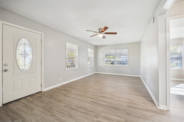 entrance foyer featuring ceiling fan, light hardwood / wood-style floors, a healthy amount of sunlight, and a textured ceiling