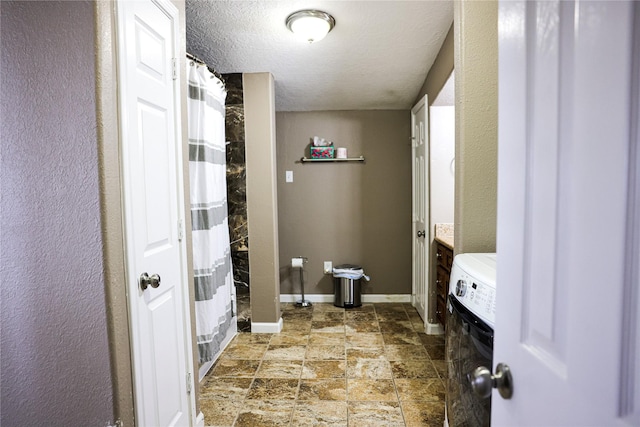 bathroom with a shower with shower curtain, a textured ceiling, and washer / clothes dryer