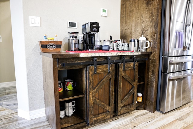 bar with stainless steel fridge and wood-type flooring