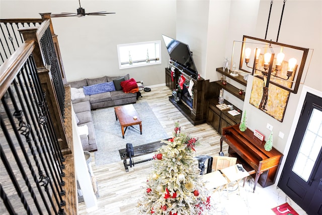 living room with light hardwood / wood-style flooring and ceiling fan with notable chandelier