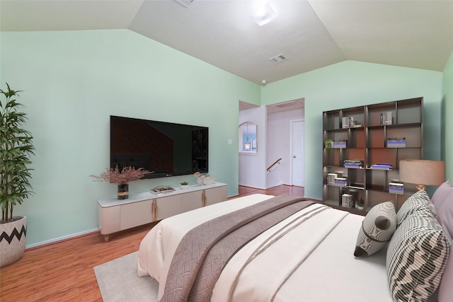 bedroom with light hardwood / wood-style floors and lofted ceiling