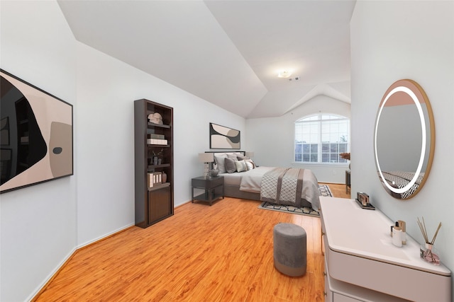 bedroom featuring light wood-type flooring and vaulted ceiling