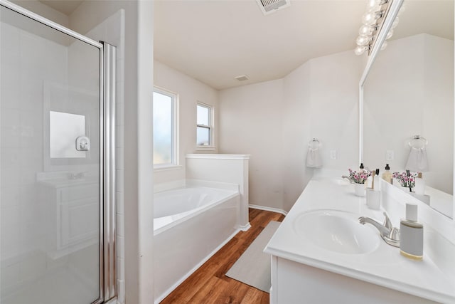 bathroom featuring vanity, wood-type flooring, and shower with separate bathtub