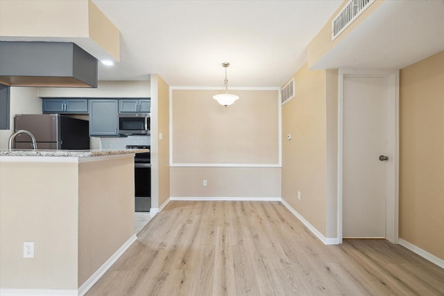 kitchen with kitchen peninsula, decorative light fixtures, decorative backsplash, appliances with stainless steel finishes, and light wood-type flooring