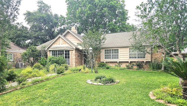 view of front of property with a front yard and cooling unit