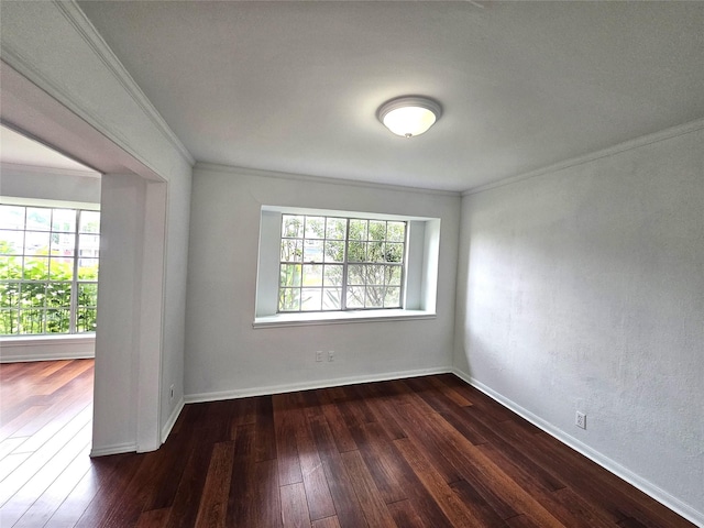 spare room featuring dark hardwood / wood-style floors, a healthy amount of sunlight, and ornamental molding