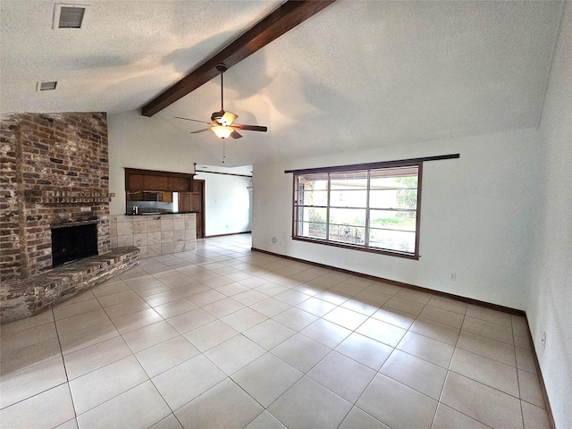 unfurnished living room featuring lofted ceiling with beams, ceiling fan, light tile patterned floors, a textured ceiling, and a fireplace