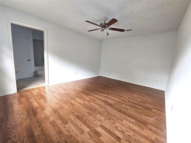 empty room featuring ceiling fan, a textured ceiling, and hardwood / wood-style flooring