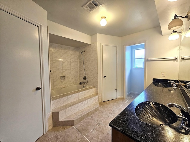 bathroom with vanity, tiled shower / bath combo, and tile patterned floors