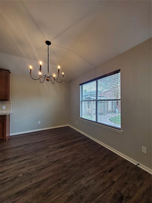 unfurnished dining area featuring dark hardwood / wood-style floors and a notable chandelier