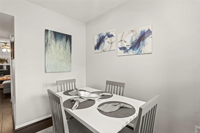 dining space with dark hardwood / wood-style floors and ceiling fan