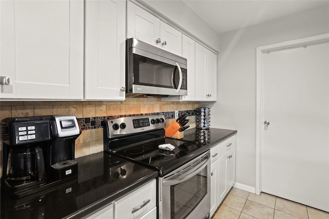 kitchen featuring light tile patterned flooring, white cabinetry, appliances with stainless steel finishes, and tasteful backsplash