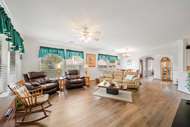 living room featuring ceiling fan with notable chandelier, light wood-type flooring, and ornamental molding