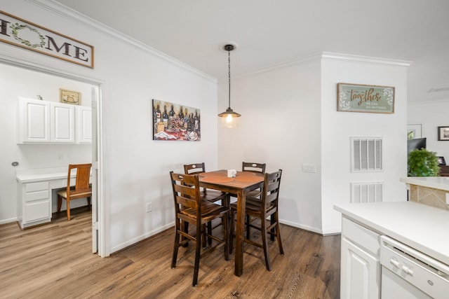 dining room with crown molding and dark wood-type flooring