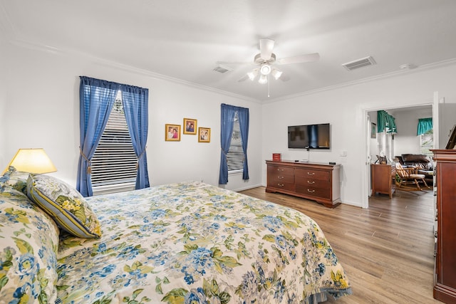 bedroom with light hardwood / wood-style floors, ceiling fan, and ornamental molding