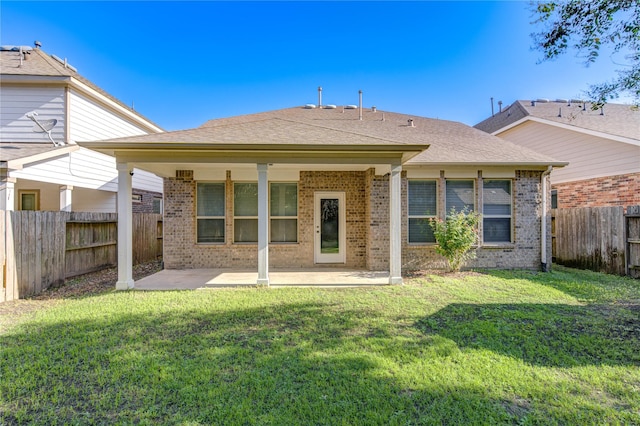 back of property featuring a patio area and a lawn