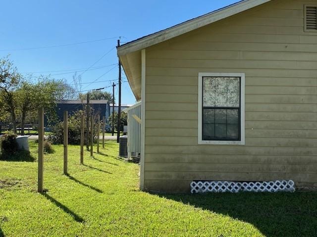 view of side of home with a yard